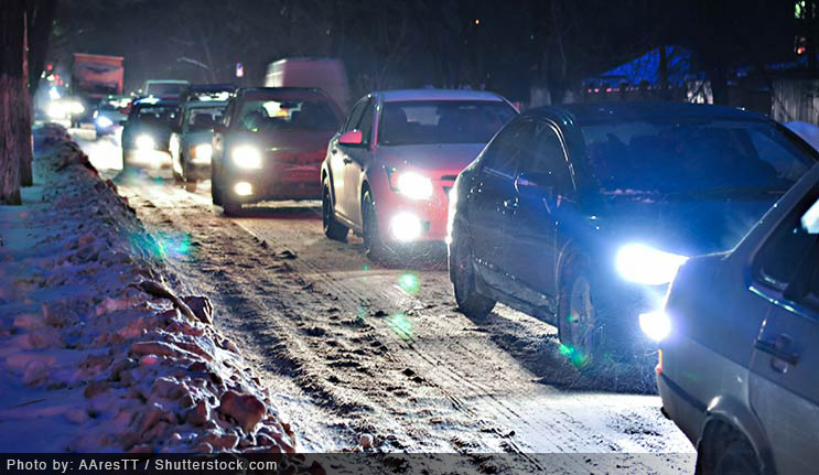 Cars on the road at night in the snow